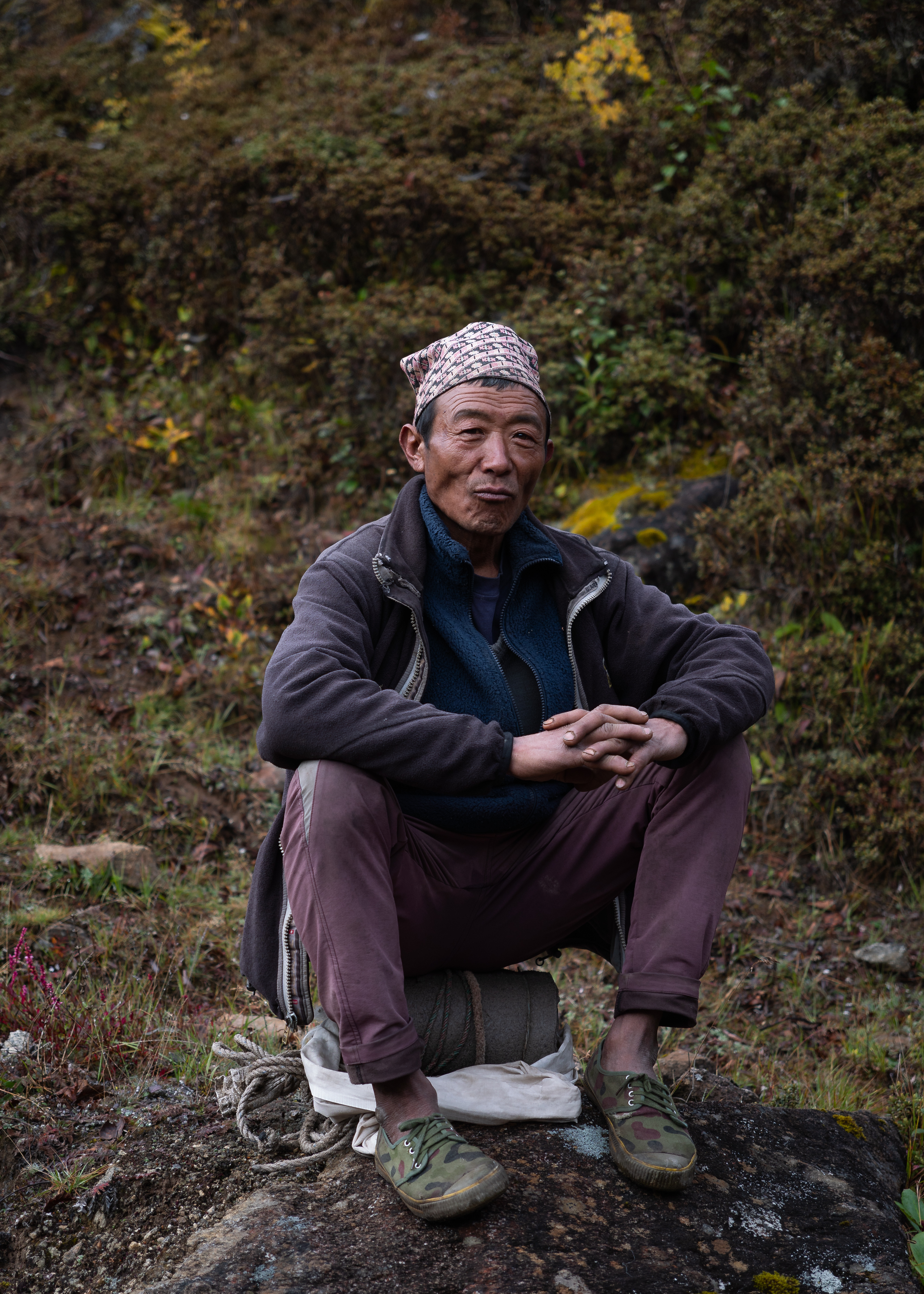 #width=100%;max-width=800px;margin-left=auto;margin-right=auto; A Sherpa man rests on the road from Khumjung to Thame.