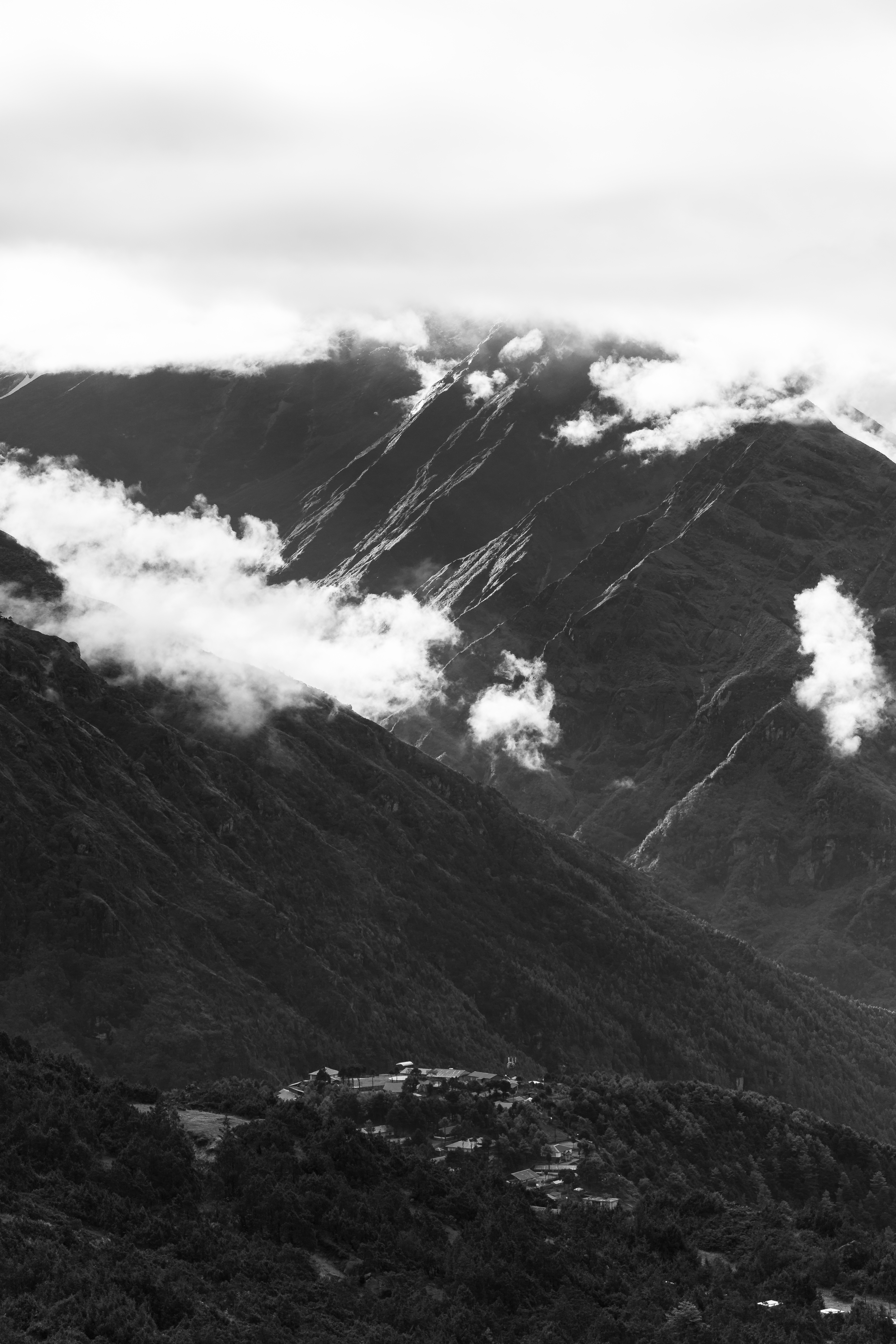 #width=100%;max-width=400px;margin-left=auto;margin-right=auto; Doing its best to disperse the clouds, the sun lights up the low slopes of Kongde Ri's eastern ridge.