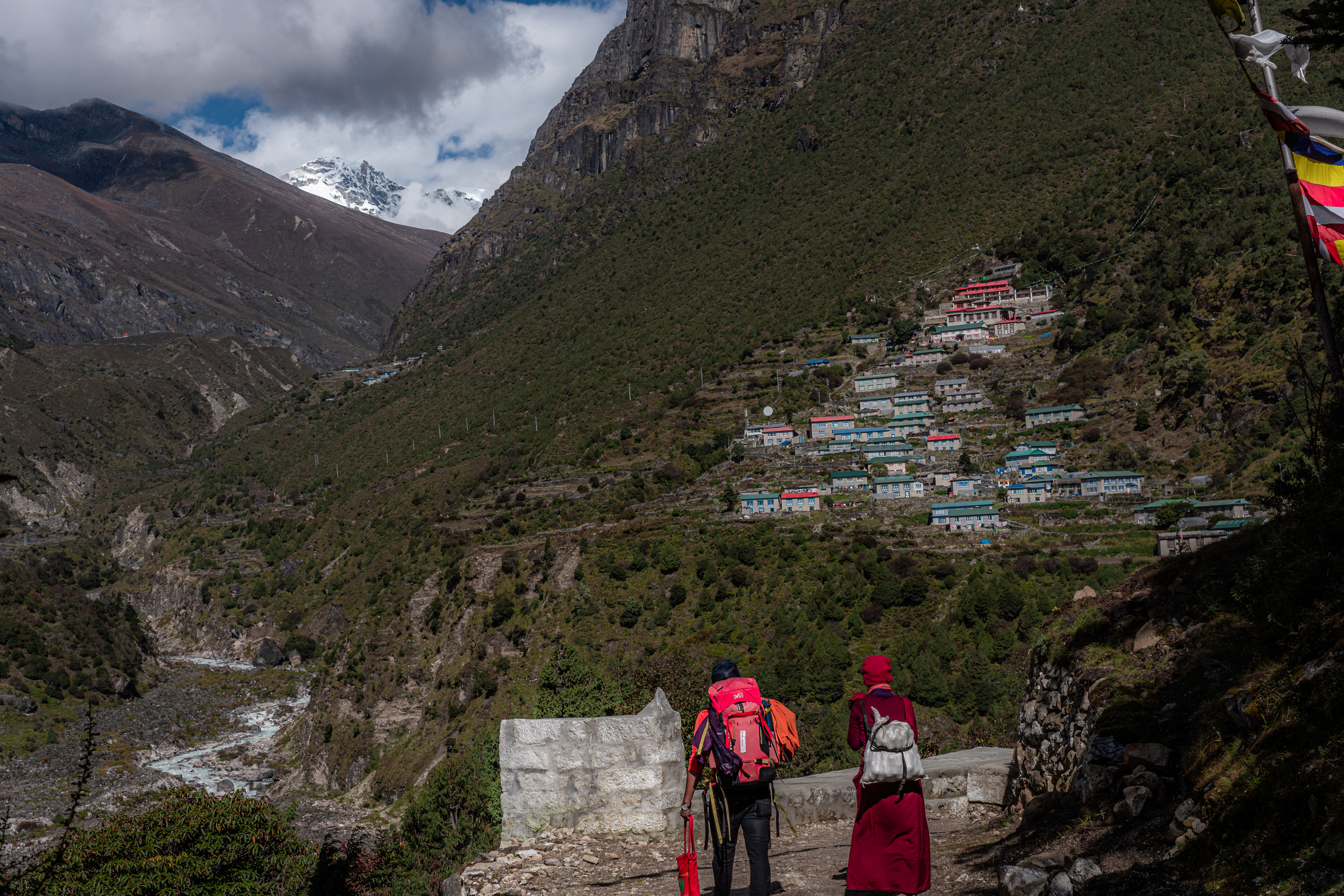 #width=100%;max-width=1000px;margin-left=auto;margin-right=auto; Pema and a sister look over Thamo. Her destination is the monastery at the top of the village. Parchemuche resides proudly down the valley toward Tibet.